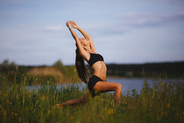 Slim young woman doing yoga outdoor. Warrior pose