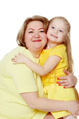 A happy mother hugs her beloved daughter.