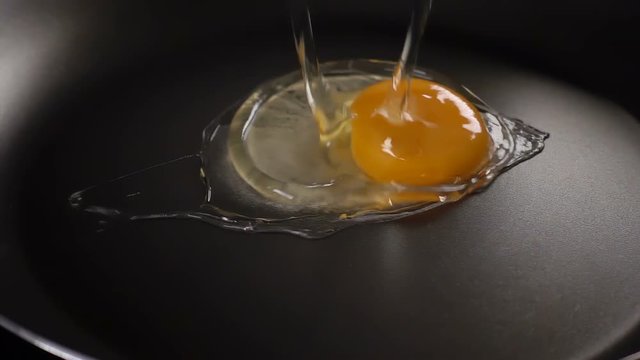 The egg falls on a hot frying pan