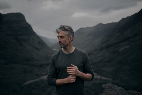 Thoughtful mature man standing in mountains