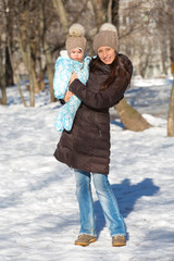 Mother and child playing in the street on a sunny winter day