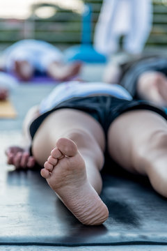 Woman Lying In Corpse Pose Relaxing After Yoga Class