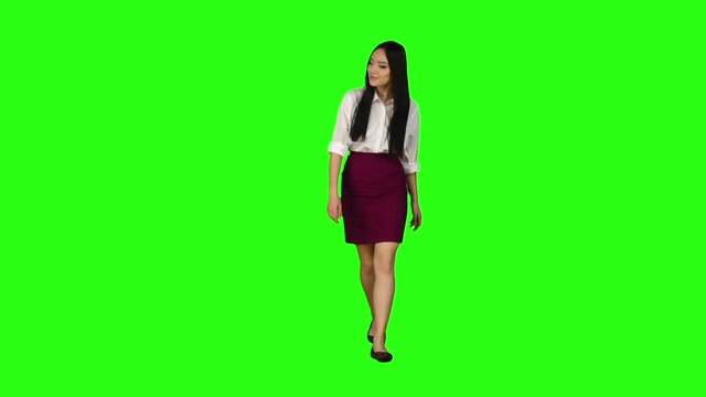 Girl looks around, chooses the right things for herself. Green screen. Slow motion