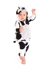 A baby in a fancy dress cow costume on a white background