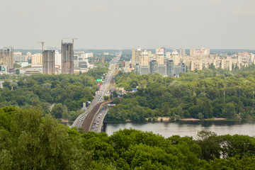 Panoramic landscape of modern developing metropolis with river, bridge, subway, parks and lots of construction