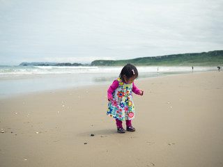 baby girl playing in the sandy beach,Northern Ireland