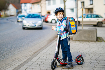 Little kid boy in helmet riding with his scooter in the city © Irina Schmidt
