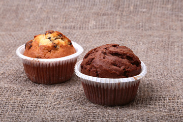 Fresh homemade muffins on Sackcloth woven texture background. Top view.