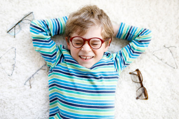 Close-up portrait of little blond kid boy with brown eyeglasses