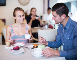 Obraz na płótnie Canvas Couple enjoying coffee at confectionery cafe