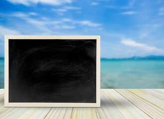 Blank chalkboard, blackboard on table with beach background with copy space, Blackboard on table for graphic apply work about business, education or other