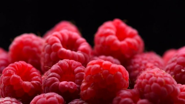 Raspberries. Fresh and juicy raspberry over black background. Rotation 360 degrees. 4K UHD video 3840X2160