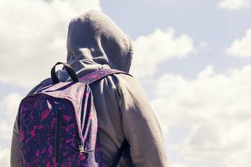 Bearded man in the hood looks at the sea
