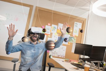 Excited man in VR headset looking at 3D planets
