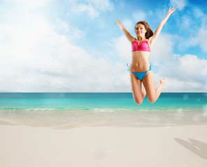 Fototapeta na wymiar Woman in bikini swimsuit jumping from joy on tropical beach