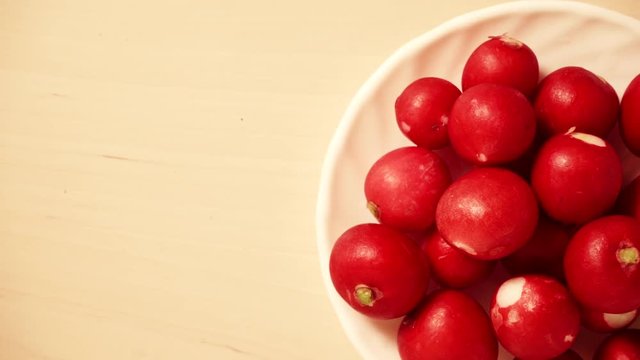 Fresh radish on plate, table background, top view. Dolly sliding shot 4K ProRes HQ codec