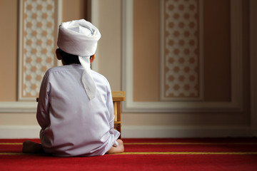Young boy in turban sitting in the masjid 