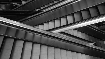 Obraz premium Modern interior design, modern escalators, chrome escalators. Black and White , monochrome, abstract artistic view. Modern art. Steel design. Architecture.