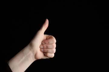 Showing a thumb up gesture. Isolated on black background. Like. more arm
