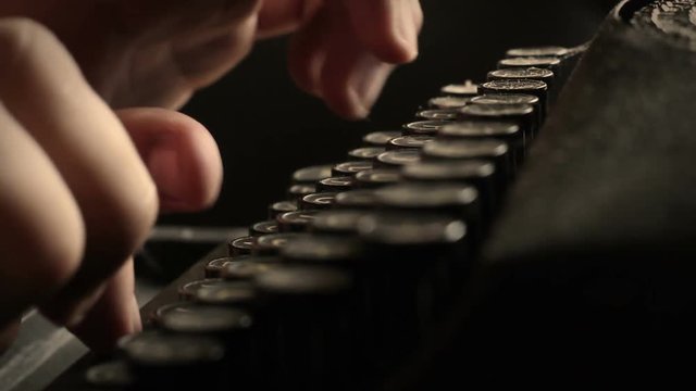 Typing on an old typewriter in a dark journalism newspaper office - Angle 1