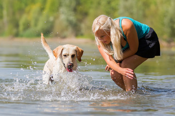 woman plays with a dog in the lake