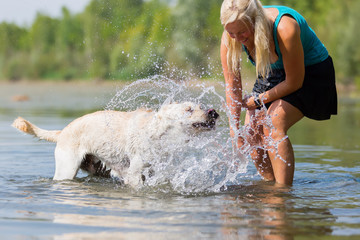 woman plays with a dog in the lake