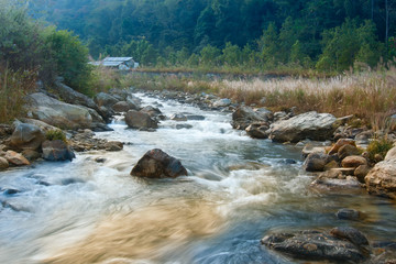 River water flowing through rocks at dawn