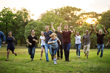 Group of people walking and running playful in the park - obrazy, fototapety, plakaty