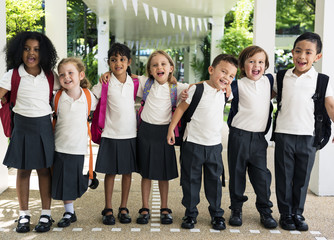 Group of diverse kindergarten students standing together in school