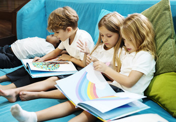 Group of Diverse Young Students Reading Children Story Book Together