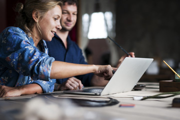 Caucasian woman poiting on computer laptop showing colleague