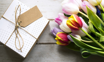 Tulip Flowers and Present with Design Space Empty Tag on Wooden Background
