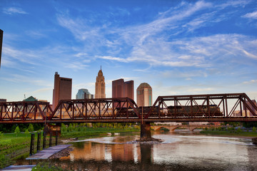 A train races across the bridge in front of the Columbus, Ohio skyline as seen from Northbank Park.
