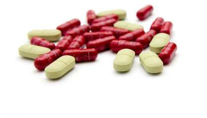 Green and red pills on a white background.