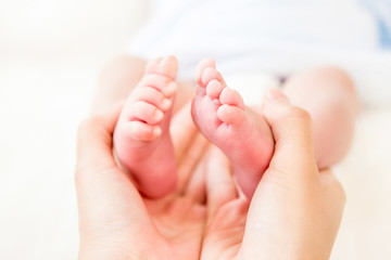 Obraz na płótnie Canvas Mother hands gently holding small baby feet