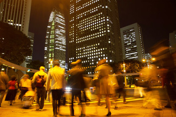 Blurred light motion people walk on street in the city night