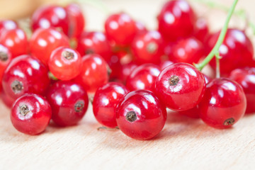 Red currant berries on wooden board background, decorative wallpaper.