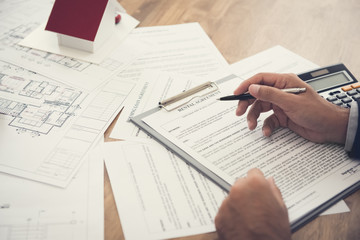 Tenant reviewing rental agreement at the table - real estate and property transaction concept