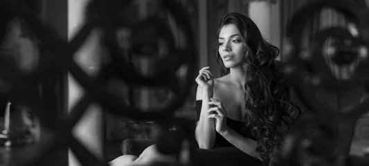 Spanierin in einem sexy Kleidchen posiert in einem Vintage-Interieur. Schönes Mädchen in erotischer Pose. Schwarz und weiß. Alter Hollywood-Stil. Retro-Foto. © Stavros