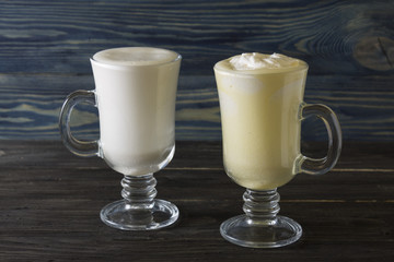 Two glasses of eggnog on a wooden table. Christmas time.