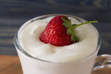 A glass with an eggnog on a wooden table