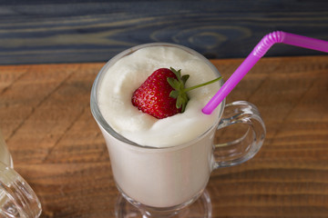 A glass with an eggnog on a wooden table