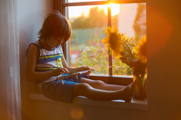Cute little toddler child, playing with abacus on a window