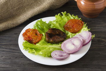 Fried meat with vegetables on a white plate. Tasty and nutritious dish.