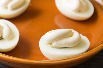 Boiled chicken eggs with mayonnaise in a clay bowl