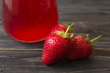 Strawberry juice in a glass jar on a wooden table. Healthy eating and cleansing the body.