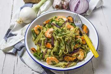 Green tagliatelle with seafood. Mussels; Prawns