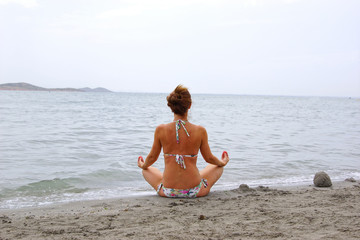 Fototapeta na wymiar Relaxing woman in pose lotus on the Mediterranean seaside. La Manga, Spain.