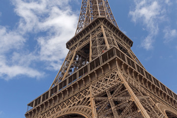 close up o Eiffel tower against blue sky with white clouds