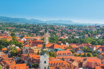 Fototapeta na wymiar Zagreb center, aerial view, rooftops and church towers, Medvednica mountain in background 